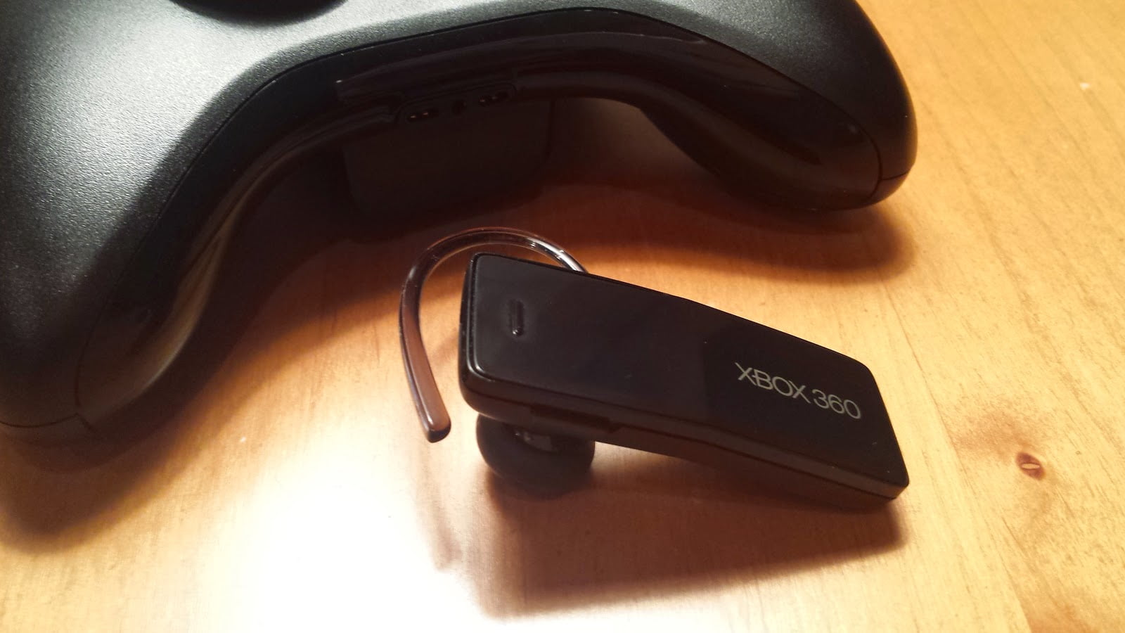 An Xbox 360 wireless headset, sitting next to an Xbox 360 controller