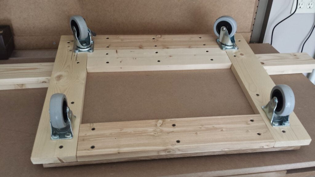Bottom view of arcade cabinet base. Rear wheels are closest to camera.