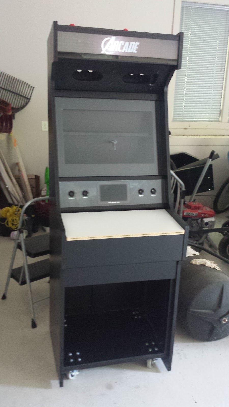 Arcade cabinet, with a blank white panel installed where the controls would usually be