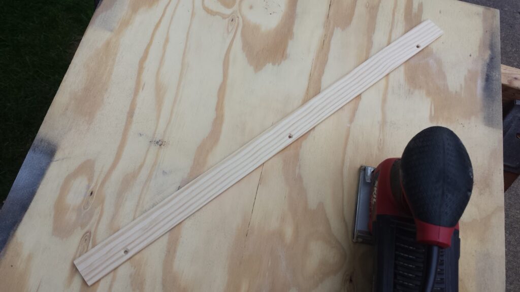 Home Depot yardstick after sanding off the logos and drilling three mounting holes.