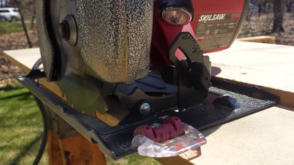 Close-up of the circular saw on the sawboard, showing that the blade is flush against the edge of the board.